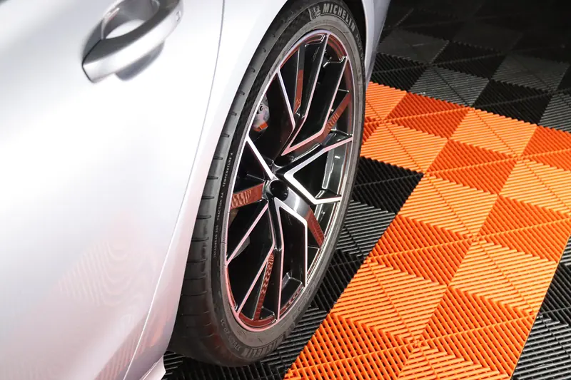 Detailaufnahme einer Audi Felge auf orangem Werkstattboden