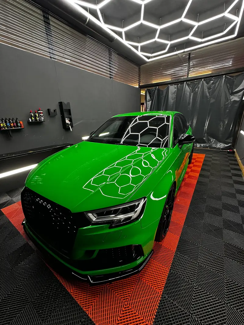Grüner Audi RS3 in unserer Werkstatt mit Hexagon-Deckenlicht und orangem Boden