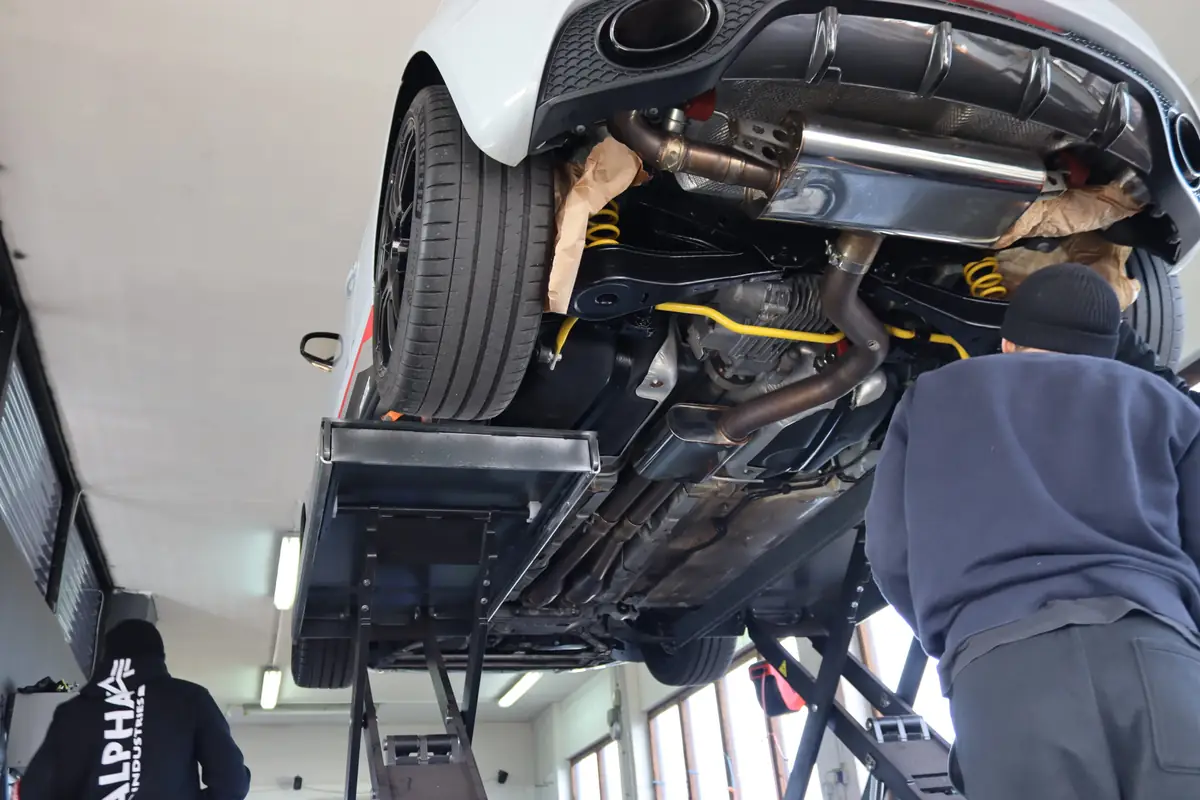 Fahrwerk und Abgasanlage von unten auf der Hebebühne