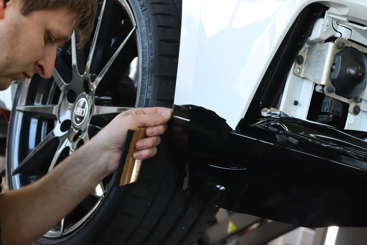 Folie wird präzise an der Stoßstange eines Audi angebracht