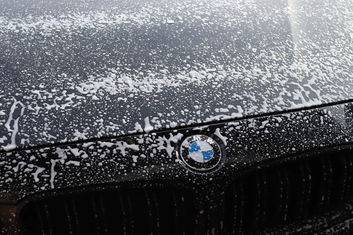 Vorwäsche mit Aktivschaum auf einem schwarzen BMW