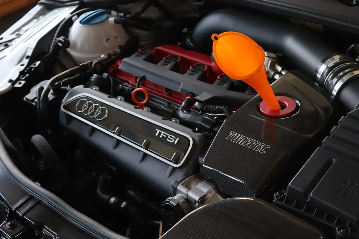 Ölwechsel an einem Audi TFSI Motor mit orangem Einfülltrichter