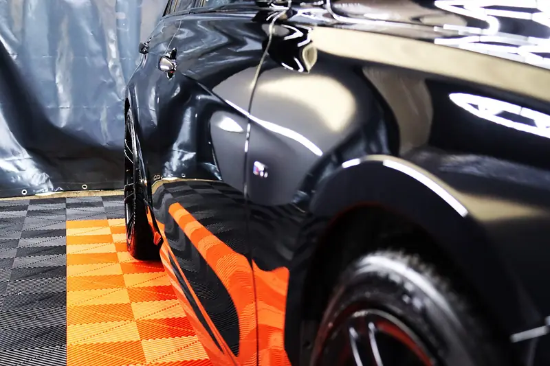 Hochglänzender schwarzer BMW Radlauf auf orangem Boden