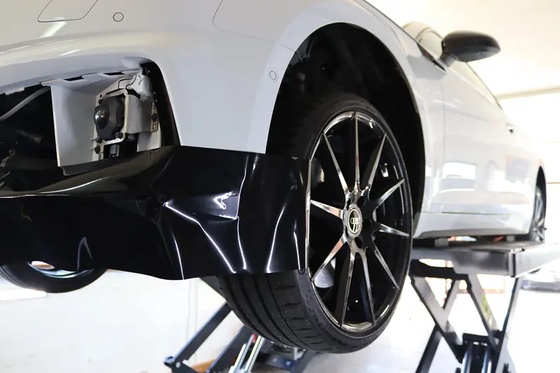 Teilfolierung an einem weißen Audi auf der Hebebühne